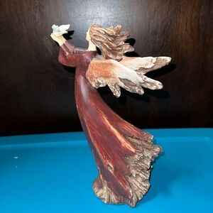 Christmas angel holding turtle dove looks like she’s part of a tree holiday deco